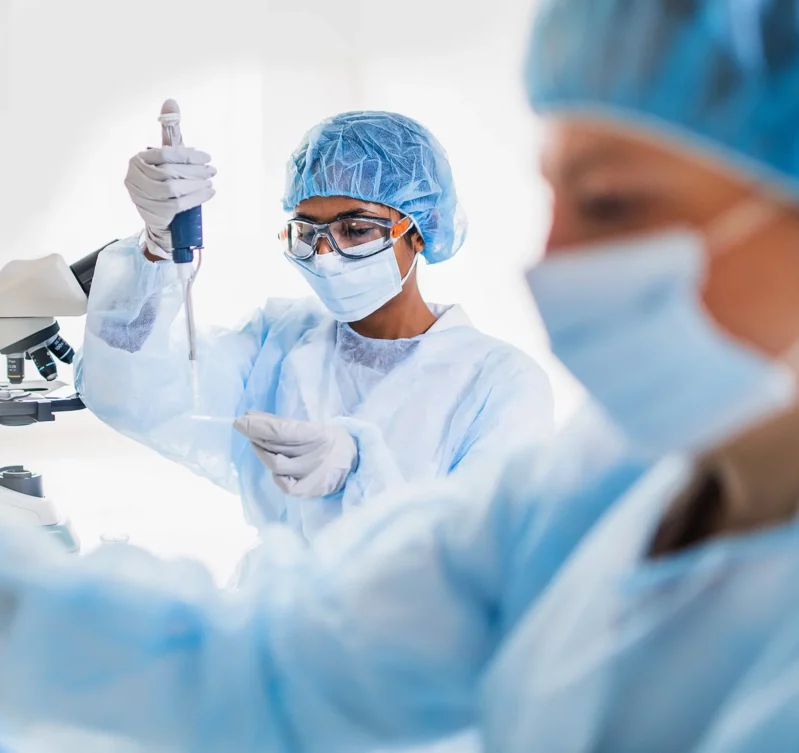 A researcher examining a sample under a microscope