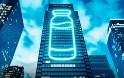 Vaccines for Life – a glowing graphic of a medicine ampule on the side of an office tower block
